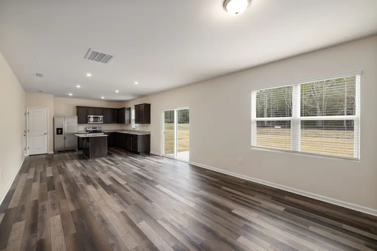 Wood-look laminate flooring through an open kitchen and living room